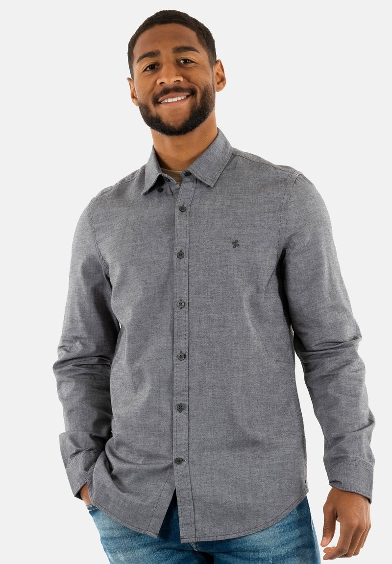 Camisa de botones de manga larga gris con una tela texturizada y un logo sutil en el lado izquierdo. Presenta un collar clásico y cierre de botones.