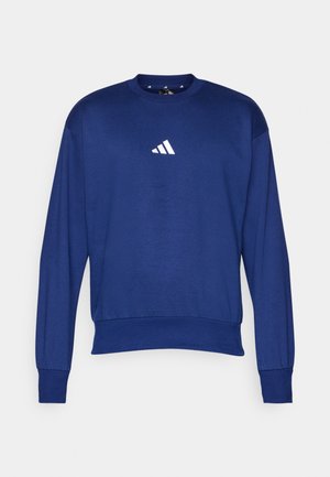 Felpa blu realizzata in morbido tessuto con maniche lunghe, scollo rotondo e logo Adidas bianco sul petto. Polsini e orlo con texture.