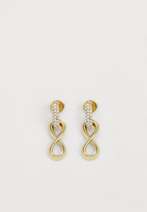 Náušnice v zlatej farbe v tvare nekonečna s pásikom ozdobeným priehľadnými kryštálmi, ktoré zdôrazňujú elegantný dizajn a lesklý povrch.