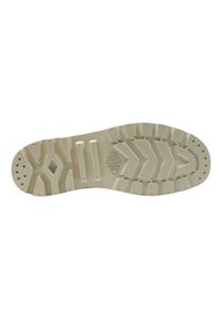 Suola di scarpa in gomma, beige chiaro con un motivo di battistrada testurizzato. Include scanalature e sezioni rialzate per una migliore aderenza. Presenta un dettaglio di branding.