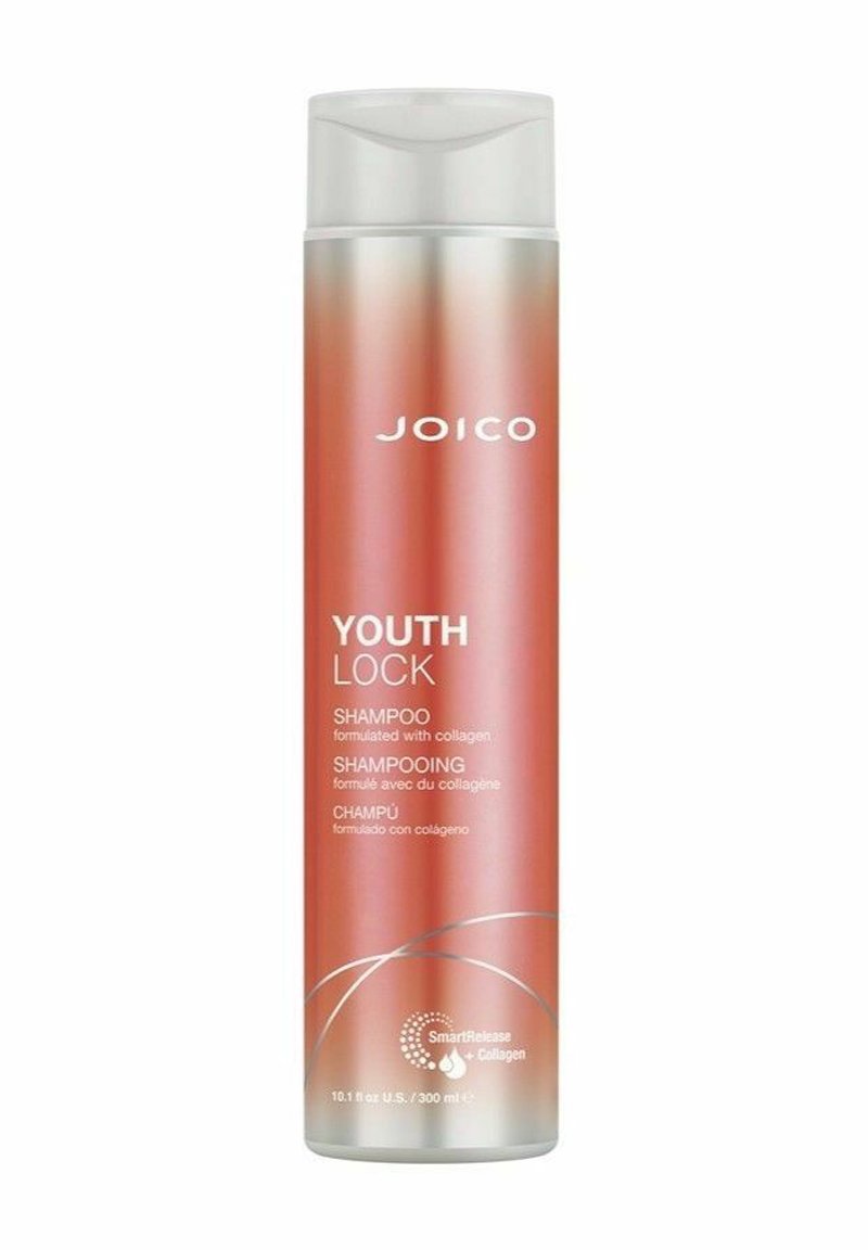 Joico Youth Lock Shampoo is in a tall, cylindrical, opaque bottle with a gradient finish from rose gold to silver and features a flip-top lid.