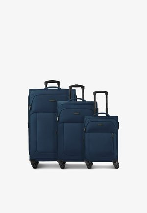 Tre valigie in soft-shell blu navy di piccola, media e grande dimensione con manici telescopici neri estesi e ciascuna con quattro ruote piroettanti.