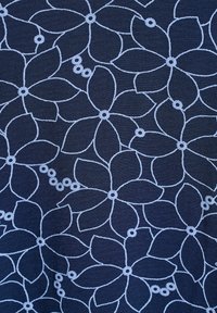 Navy fabric with embroidered light blue floral pattern featuring large petals and circular accents, creating a textured, layered design.