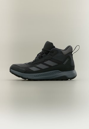 Μαύρο και γκρι adidas Terrex ψηλό πεζοπορικό παπούτσι με υφή στην σόλα και θηλιά για τράβηγμα, σχεδιασμένο για υπαίθρια χρήση και ανθεκτικό στις καιρικές συνθήκες.