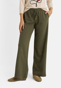 Pantalon à jambes larges vert olive en tissu doux, doté d'une taille élastique avec un cordon de serrage et deux poches latérales.