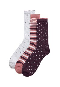 Tres pares de calcetines: grises con puntos negros, rosa a rayas y morado oscuro con corazones blancos. Todos presentan una tela de punto texturizada.