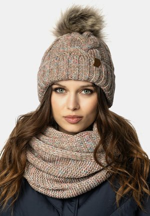 Strik beanie og tørklædesæt i beige med flerfarvede nubrer. Beanie'en har et struktureret mønster og en pels pom-pom på toppen.