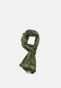 Bufanda verde hecha de tela suave, con un patrón sutil, bordes con flecos y una textura lisa, envuelta en un estilo en bucle.