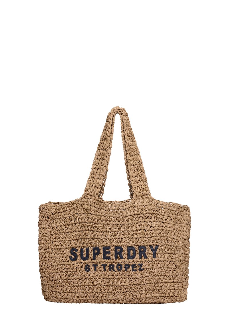 Geweven rieten draagtas in natuurlijke kleur met zwarte gedrukt tekst "SUPERDRY ST TROPEZ," met twee stevige handgrepen en een rechthoekige vorm.