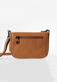 Borsa a tracolla in pelle marrone con tasca frontale con zip, forma curvata, tracolla regolabile e texture liscia. Presenta accenti di cucitura minima.