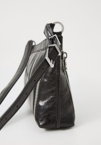 Sac à main en cuir noir avec une texture brillante, doté d'une double fermeture éclair, d'une bandoulière réglable et d'accents en métal argenté.