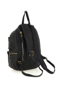 Zaino in pelle nera con borchie e zip dorate, spallacci regolabili e maniglia superiore su uno sfondo bianco.