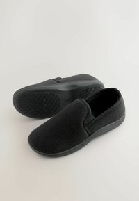 Juodi šlepetės su slip-on dizainu, pagamintos iš tekstūruotos medžiagos su žuvų kaulų raštu. Guma, padengta deimanto raštą turinčia sluoksniu, užtikrina gerą sukibimą. Minkštas pamušalas viduje.