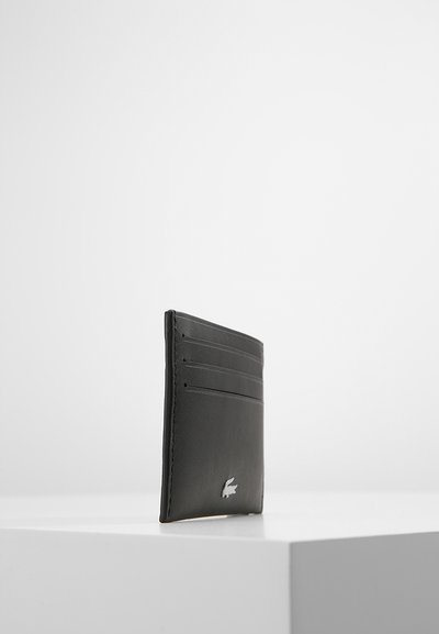 Portefeuille en cuir noir avec plusieurs emplacements pour cartes, au design épuré et à accent logo argent. Forme plate et texture lisse.