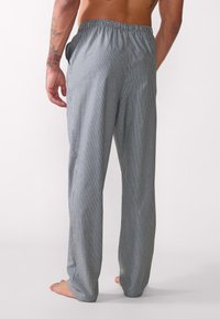 Pantaloni da pigiama a righe con vita elastica, realizzati in tessuto morbido. Presentano tasche laterali e una vestibilità ampia, in tonalità di blu e bianco.