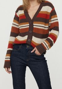 Multicolored knit cardigan with a V-neck, featuring horizontal stripes in rust, cream, and brown, and five large buttons at the front.