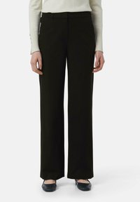 Zwarte wijde broek gemaakt van gladde stof, met een tailored fit, riemlussen en een plooi aan de voorkant.