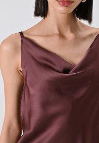 Burgunderfarbene Seiden-Camisole mit einem Cowl-Ausschnitt und schmalen, verstellbaren Trägern, ausgestattet mit einer glatten Textur und dezentem Fallen.