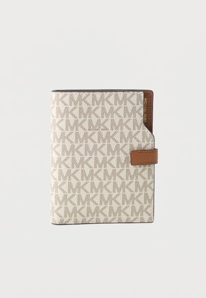 Michael Kors bézs pénztárca ismétlődő "MK" mintával, barna bőrfüllel és arany logóval világosszürke háttéren.