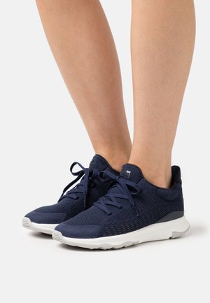 Marineblaue Sportschuhe mit einem Mesh-Obermaterial, strukturierten Akzenten und einer weißen Gummisohle. Sie verfügen über Schnürsenkel und einen gepolsterten Kragen für zusätzlichen Komfort.