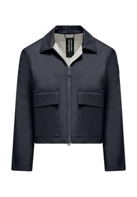 Giacca cropped blu navy con zip frontale, colletto appuntito, due tasche sul petto e una superficie liscia. Etichetta visibile all'altezza del colletto.