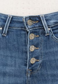 Τζιν παντελόνι ψηλόμεσο σε μπλε χρώμα, με κούμπωμα κουμπιών που περιλαμβάνει πέντε μεταλλικά κουμπιά και ραφές σε αντίθεση. Ομαλή υφή με ελαφριά ξεθώριασμα.