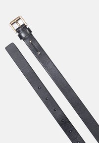 Svart läderbälte med en slät yta, utrustad med en spänne i guldton, fem justeringshål och subtil logotyp på remmen.