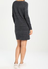 Abito maglione grigio scuro lavorato a maglia con maniche lunghe, scollatura rotonda e silhouette dritta, che arriva a metà coscia con texture a coste.