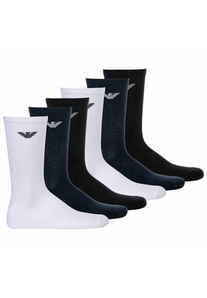 Six paires de chaussettes côtelées : deux blanches, deux marine et deux noires. Chaque paire présente un petit logo au-dessus de la cheville dans une couleur contrastante.