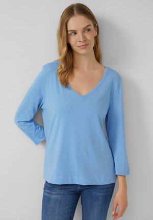 Lichtblauw langemouwen V-hals shirt met een relaxte pasvorm en zachte textuur. Heeft een eenvoudig ontwerp zonder patronen of zichtbare hardware.