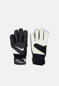Guanti da portiere in bianco e nero con presa testurizzata, polsino elastico e palmi imbottiti. Presentano il logo Nike e una cinghia regolabile.