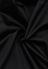 Black fabric with a smooth, matte texture, tightly twisted in folds, showing soft sheen and consistent color throughout.