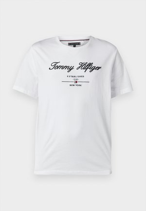 Bílá bavlněná trička s vyšitým názvem značky "Tommy Hilfiger", pod nímž je text "Established 1985" a "New York". Krátké rukávy.