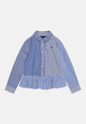 Camisa de manga larga a rayas azules y blancas con dobladillo con volantes, cierre de botones y logo polo. Presenta un cuello y puños con rayas en contraste.