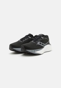 Scarpe sportive nere con tomaia in rete, design delle stringhe simmetrico e accenti riflettenti argento. Suola bianca spessa con battistrada nero testurizzato.