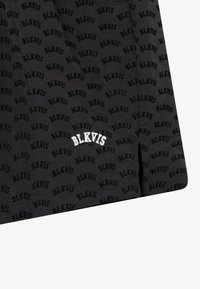 Mustad mustrihapped, millel on kogu pinna ulatuses BLKVIS muster, valge brodeeritud logo ääres ja külgsilma avad lisadetailideks.
