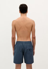 Shorts de bain pour hommes en bleu foncé. Taille élastique, poche arrière avec rabat, tissu léger et longueur au-dessus du genou.