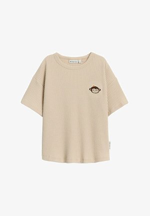 Beige t-shirt met wafelstructuur, korte mouwen, ronde hals en geborduurd aapdesign op de linkerkant van de borst. Label aan de zijkant.