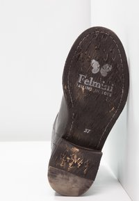 Semelle usée en cuir marron foncé avec logo papillon, texte "Felmini FALLING IN LOVE" et taille 37 sur fond blanc.