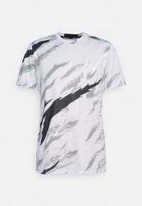 Camisa deportiva de manga corta en blanco con un patrón abstracto negro texturizado, con cuello redondo acanalado y dobladillo recto.