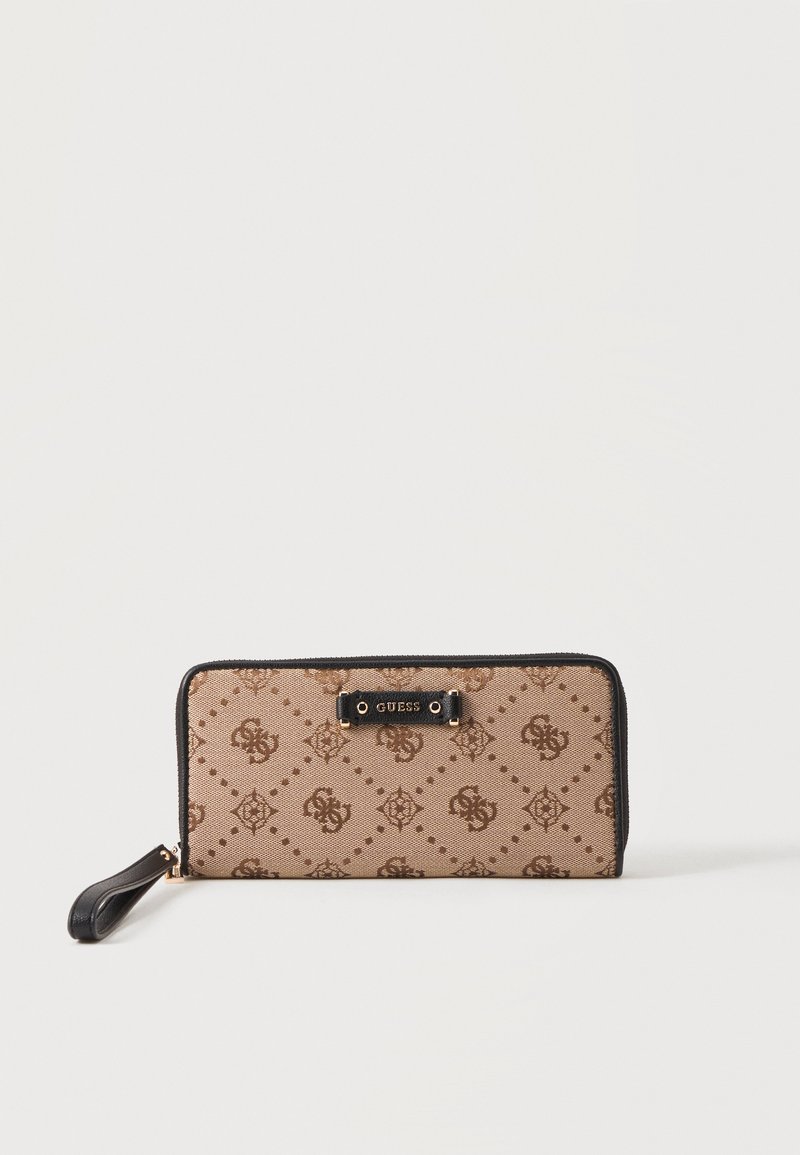 Portefeuille rectangulaire beige Guess avec motif logo marron foncé, bordure noire, fermeture éclair et sangle de poignet sur fond blanc.