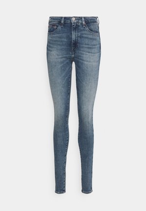 Niebieskie obcisłe jeansy z denimu z przodu na guziki i suwak, z kieszeniami z przodu i z tyłu oraz lekkim wyblaknięciem na udach i kolanach.