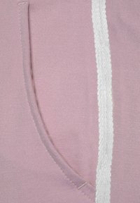 Rosa Stoff mit strukturiertem Finish, der mit einem weißen Akzentstreifen und einer seitlichen Tasche mit abgerundeten Kanten versehen ist, was das lässige Design unterstreicht.