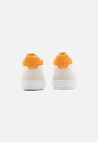 Baskets montantes en suede blanc et orange, avec un bout arrondi, des panneaux texturés et un col rembourré avec un détail de logo sur la semelle.
