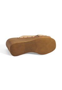 Houten schoen met een tan onderkant, voorzien van een roze bovenkant met bronzen studs. De textuur is glad met een ronde, vormgegeven schuilplaats.