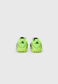 Zwarte en neon groene voetbalschoenen met een gestructureerd oppervlak, voorzien van opvallende merkvermelding en een lichtgewicht ontwerp voor verbeterde prestaties.