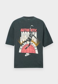 Μαύρο βαμβακερό κοντομάνικο μπλουζάκι με κοντά μανίκια, που απεικονίζει πολύχρωμο γραφικό σχέδιο παίκτη που κάνει κάρφωμα, στοιχεία κειμένου και το λογότυπο της Nike.