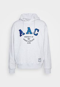 Pilkas džemperis su gobtuvu, su priekinėje pusėje esamu grafiniu elementu, kuriame užrašyti "AAC", "PROPERTY OF" ir "ADIDAS ATHLETIC CLUB" juodos ir mėlynos siuvinėjimo spalvomis. Reguliuojamas gobtuvas.