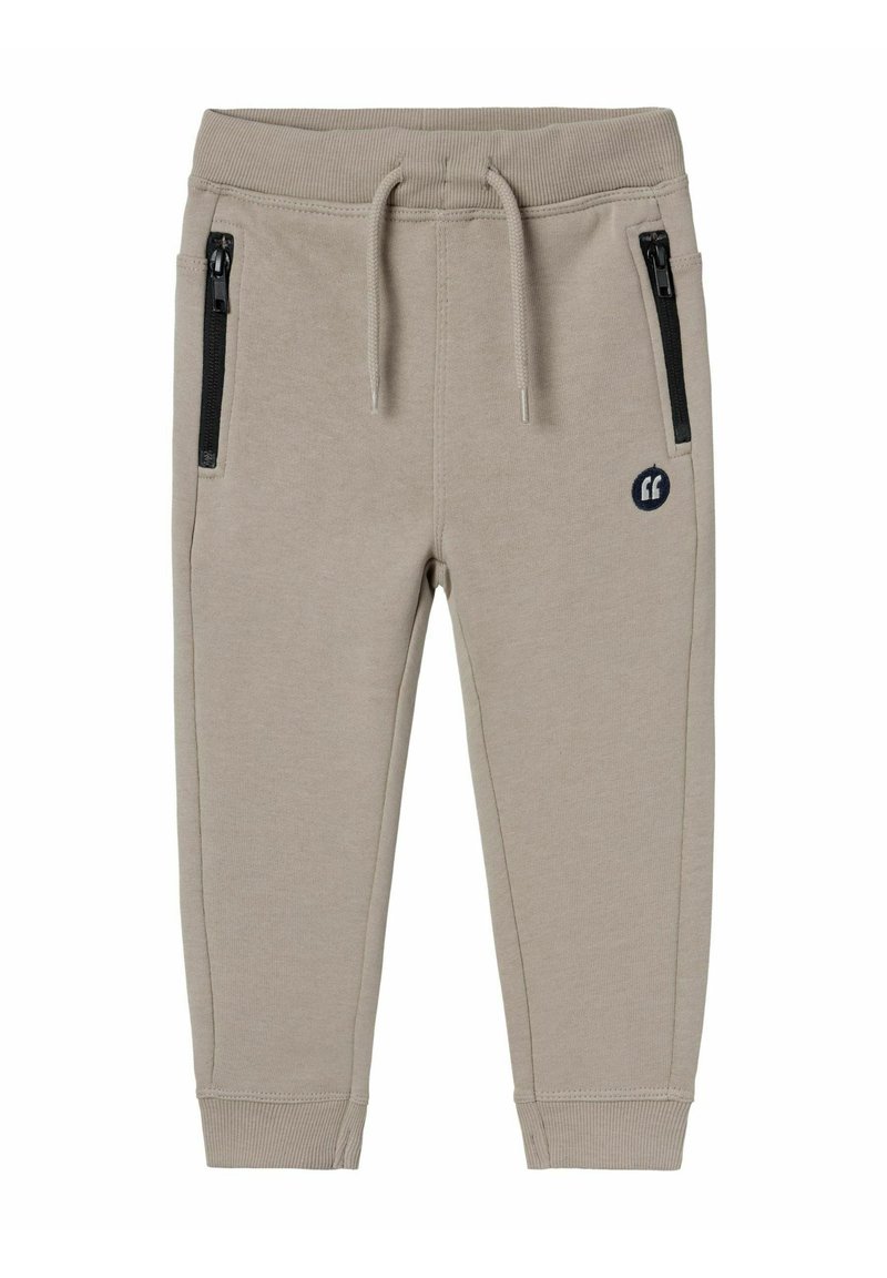 Beige sweatpants made of cotton blend, featuring ribbed cuffs, drawstring waist, and two zippered side pockets with black hardware.