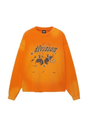 Fel oranje sweatshirt met lange mouwen en een zwarte afbeelding van twee cowboys die op stieren rijden, omringd door sterren en de tekst "The division" over de borst.